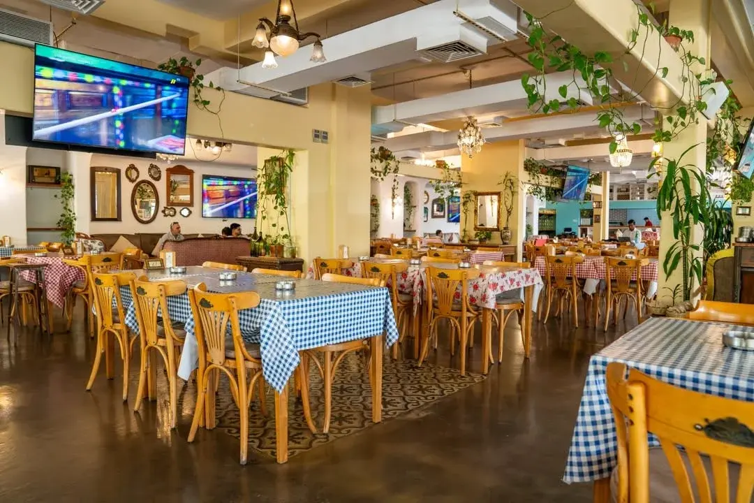 The dining room laid for lunch, checked cloths and bentwood chairs, Al Falamanki Doha