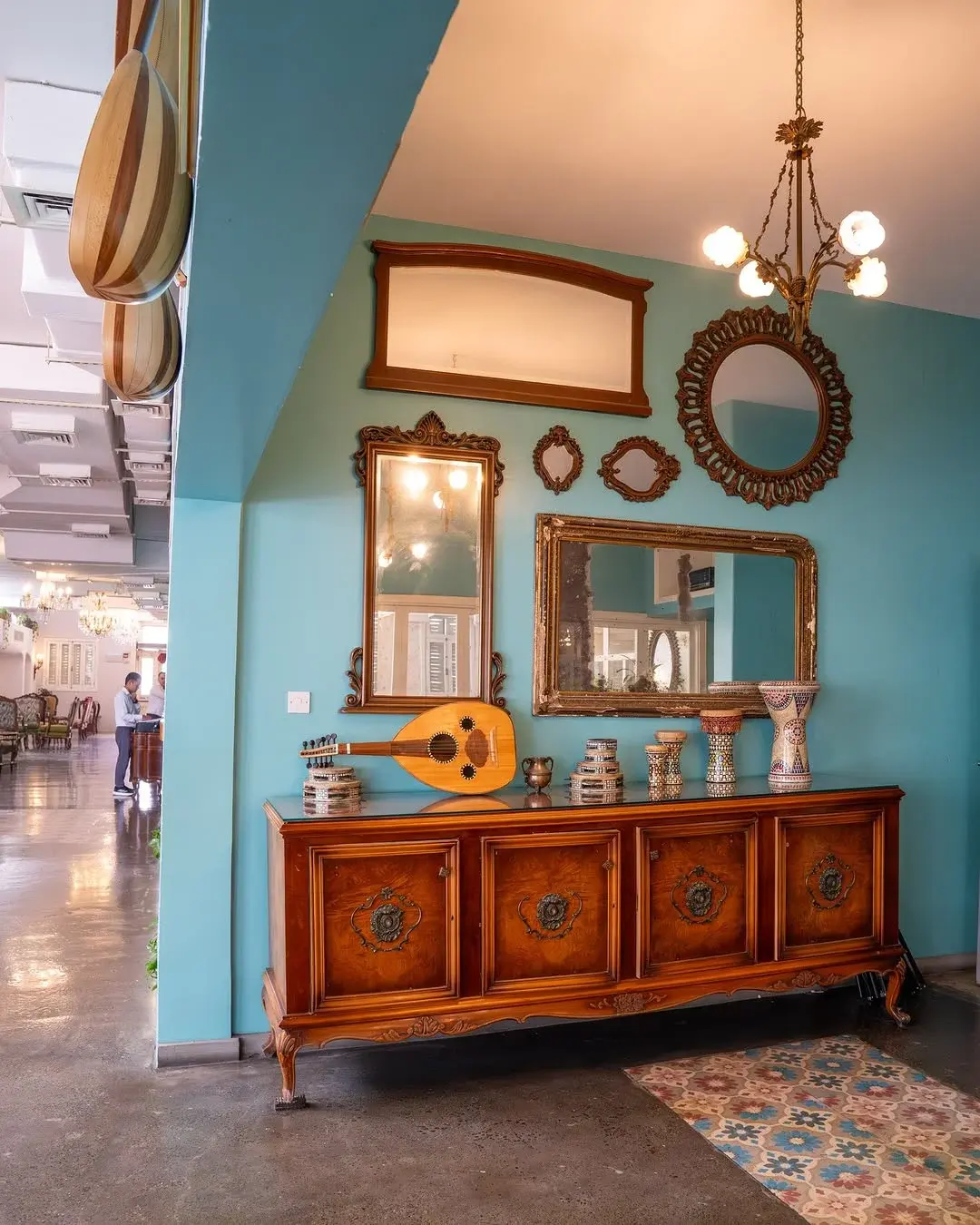 Painted mirrors and a carved sideboard on the teal wall, Al Falamanki Doha