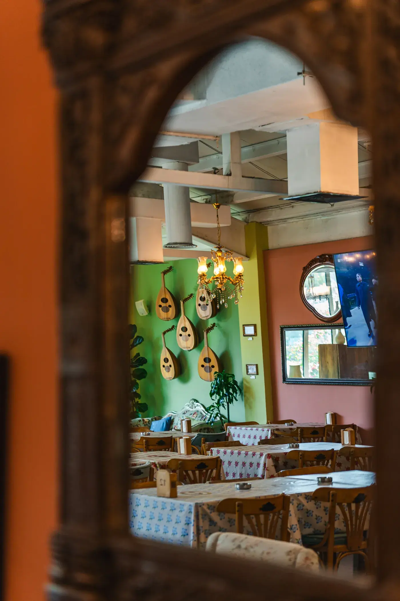 A carved wooden mirror reflecting the dining room, Al Falamanki Dubai