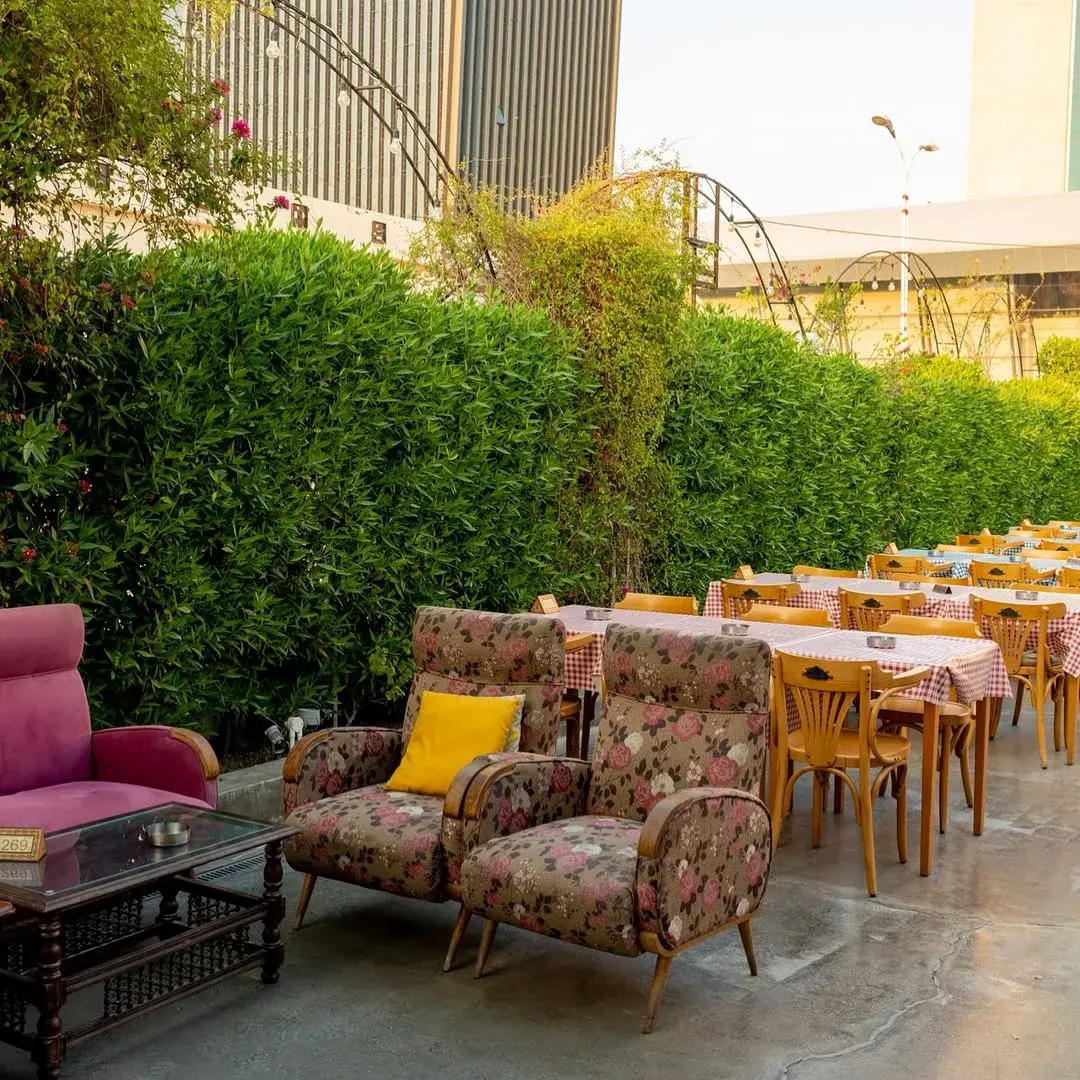 The outdoor terrace between clipped hedges, Al Falamanki Doha